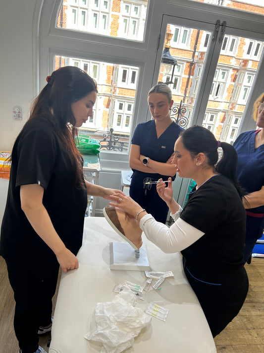Aesthetic practitioner demonstrating safe injection technique to avoid complications — advanced complications management course
